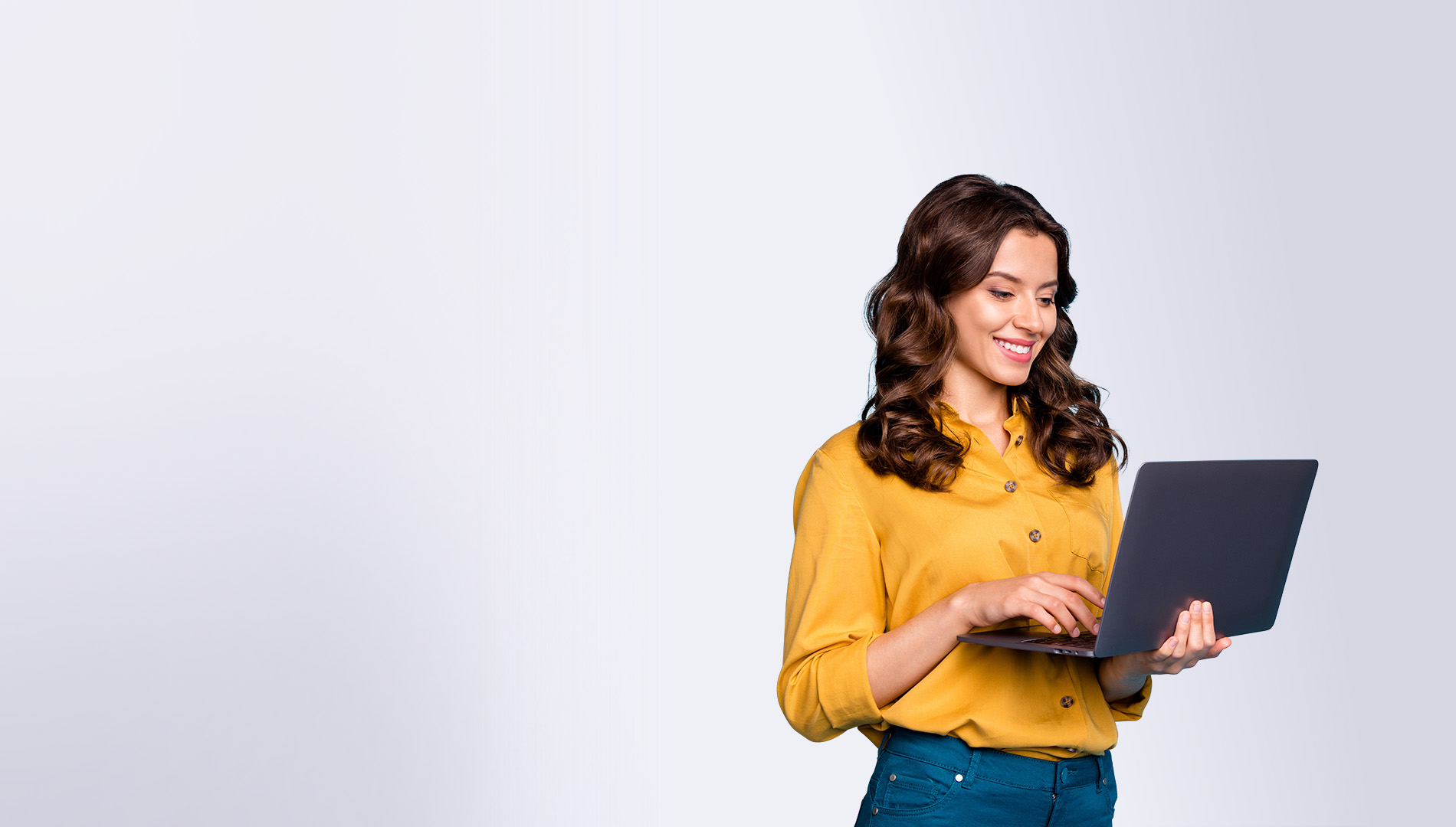 cheery wavy-haired girl holding in hands laptop