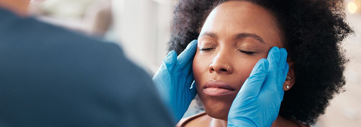 doctor with hands on side of black womans face