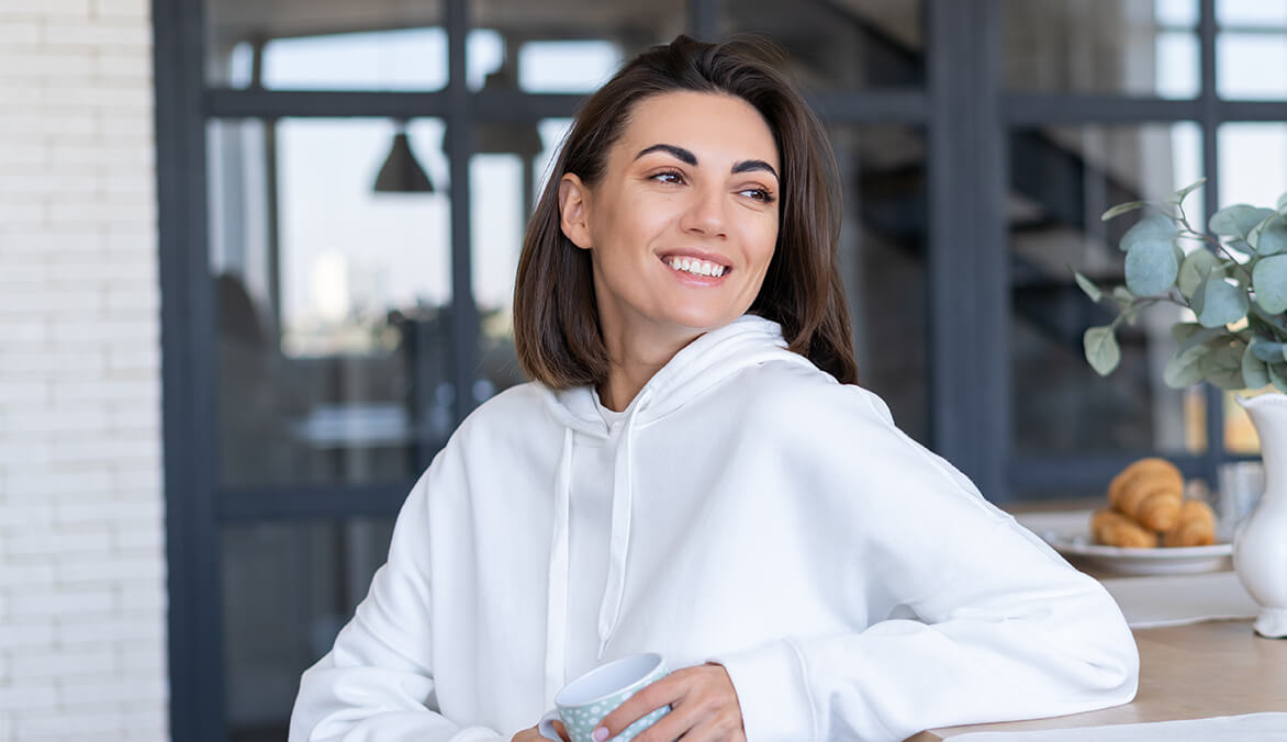 young-woman-warm-white-hoodie-home-kitchen-starts-her-day-with-cup-coffee