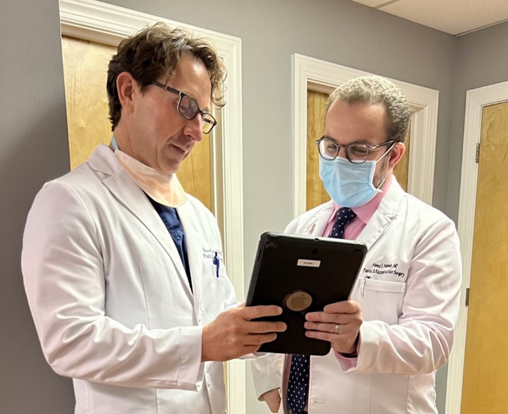 two-physicians-looking-at-tablet-in-hallway