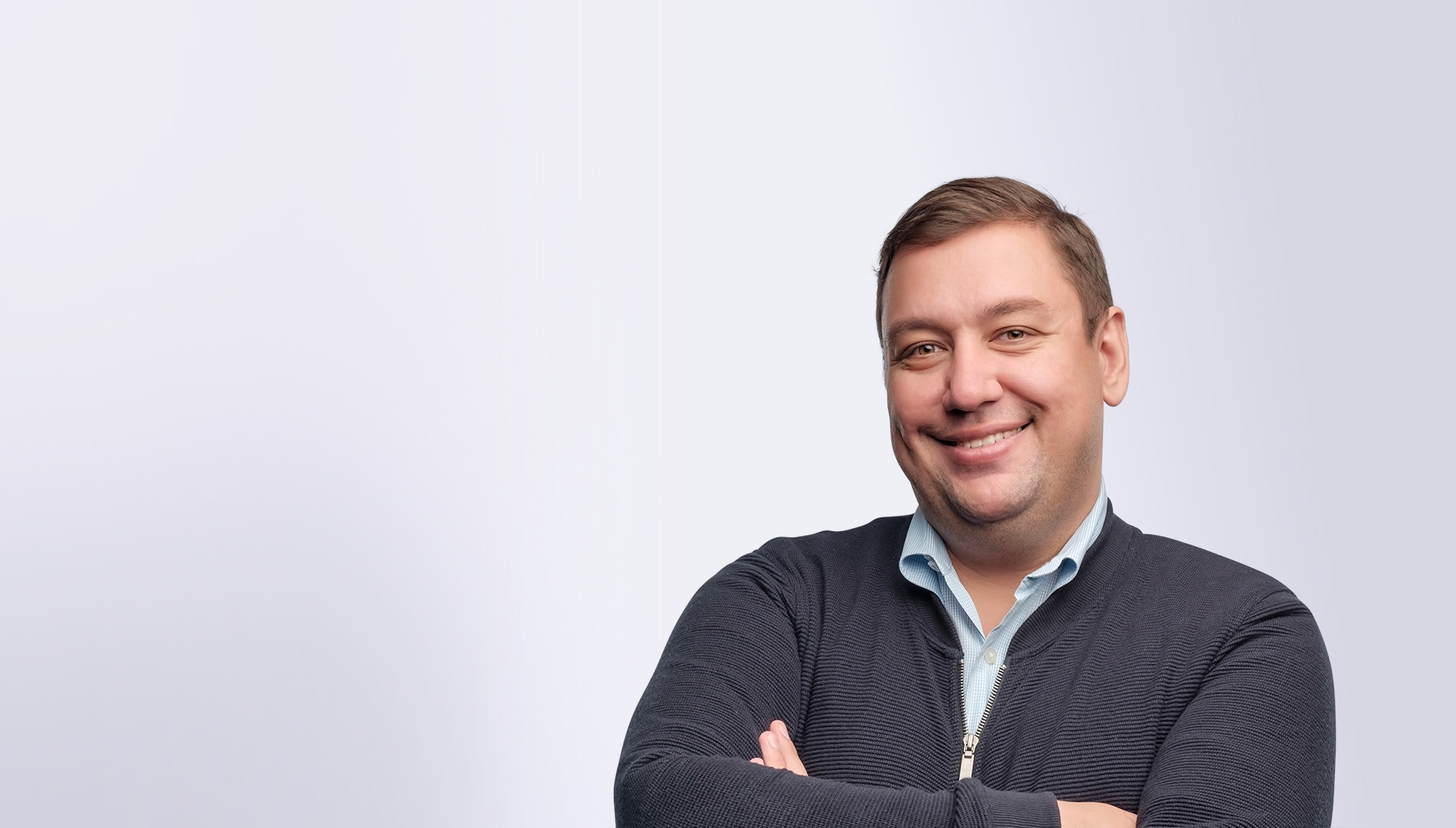 portrait of confident middle aged man with folded arms smiling